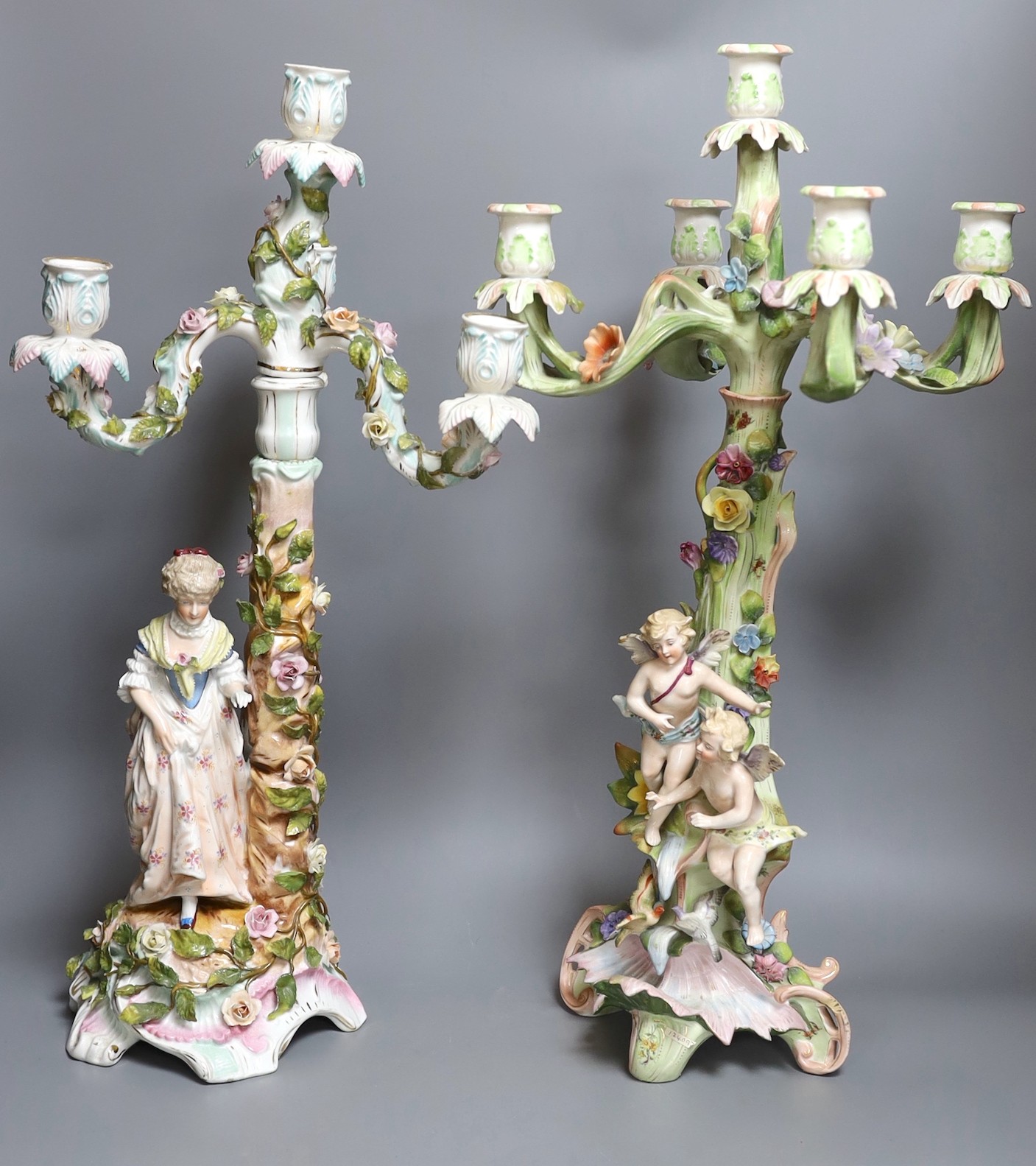 Two German floral encrusted candelabra, tallest 55cm